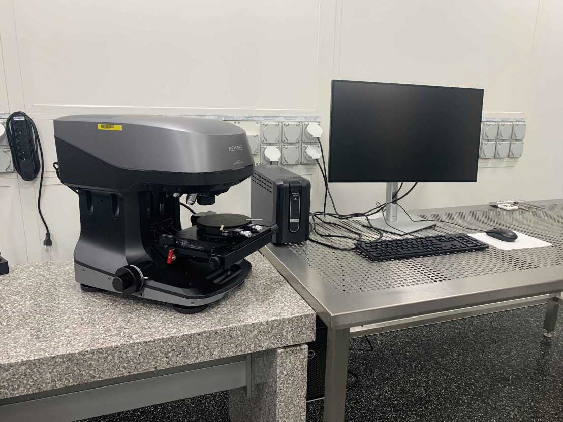 Enlarged view: photo of a laser scanning microscope on a granite table with a computer workstation next to it