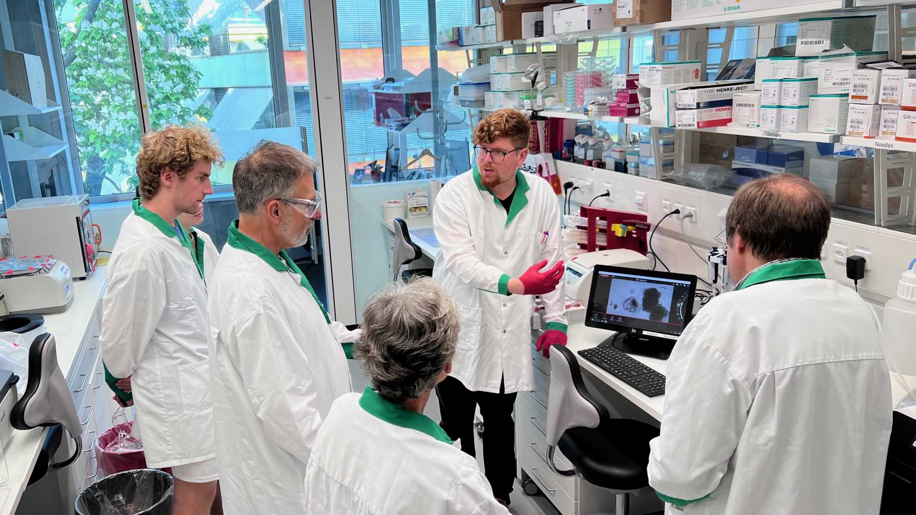 PhD student Jonas Kretz presents cancer organoids to visitors.