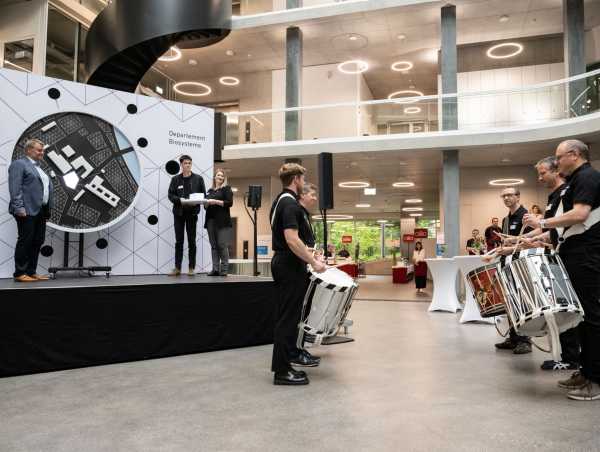 Drummers and students delivering the missing piece, the BSS building, to the light sculpture on stage, representing the Schällemätteli-campus